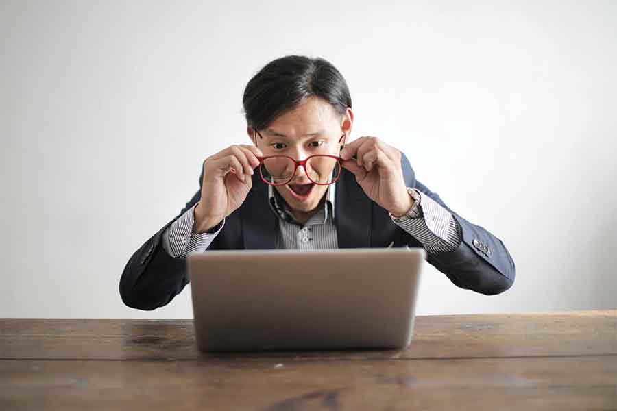 Man looking through his glasses at his computer, potentially admiring the great User Experience