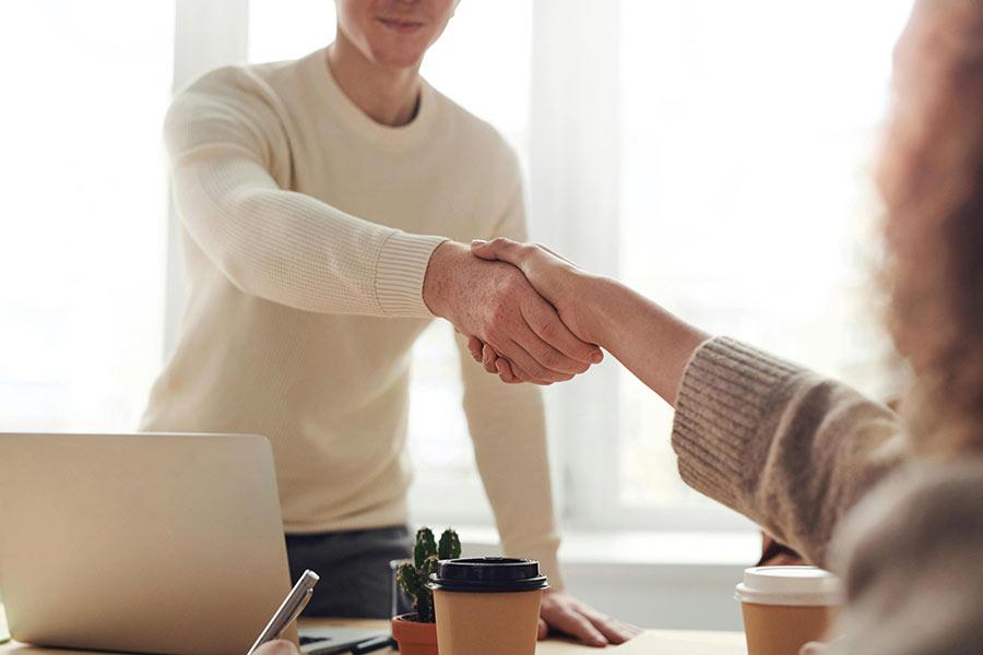 Photo showing a handshake between two business partners highlighting affiliate partners marketing. Photo by fauxels: https://www.pexels.com/photo/man-and-woman-near-table-3184465/